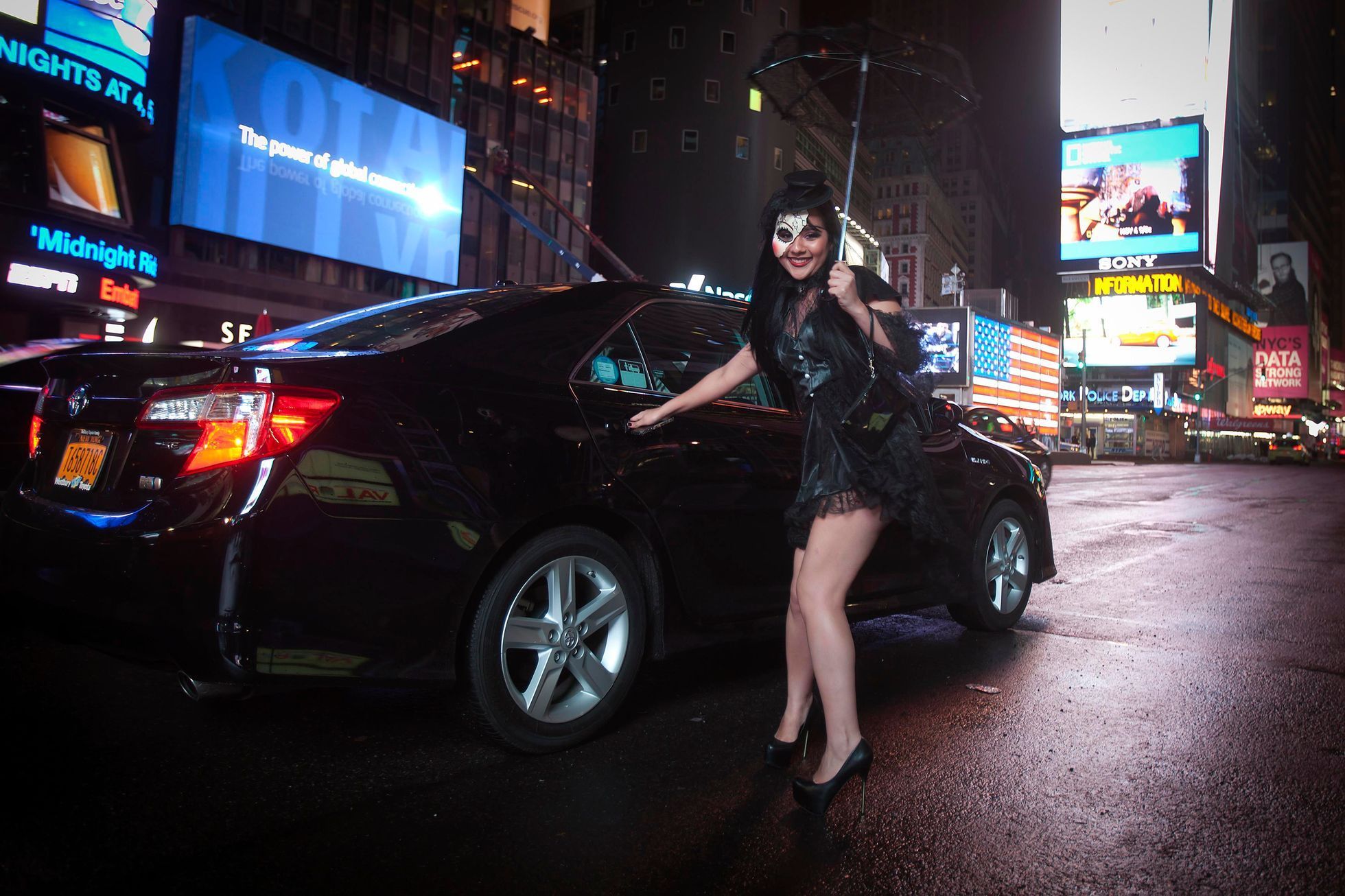 Halloween reveller smiles as she gets into a cab after waiting in Times Square for a taxi early in the morning in the Manhattan borough of New York
