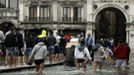 Tourists walk on raised platforms for flood waters in St. Mark Square during a period of seasonal high water in Venice October 27, 2012. The water level in the canal city rose to 127 cm (50 inches) above the normal level, according to the monitoring institute. REUTERS/Manuel Silvestri (ITALY - Tags: ENVIRONMENT SOCIETY TRAVEL) Published: Říj. 27, 2012, 12:33 odp.