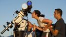 Anita Sokal-Davidson (L) of Rochester, New York, is helped by Tim Stevens as she looks through a telescope from Cobbs Hill Reservoir as the planet Venus transits across the sun over Rochester, New York, June 5, 2012. The planet Venus made a slow transit across the face of the sun on Tuesday, the last such passing that will be visible from Earth for 105 years. REUTERS/Adam Fenster (UNITED STATES - Tags: ENVIRONMENT SCIENCE TECHNOLOGY) Published: Čer. 6, 2012, 3:32 dop.