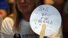 A woman in the audience holds a handwritten sign reading "Still Voting for Obama, See No Reason to Change" at a campaign rally with Republican presidential nominee Mitt Romney in Apopka, Florida October 6, 2012. REUTERS/Brian Snyder (UNITED STATES - Tags: POLITICS ELECTIONS USA PRESIDENTIAL ELECTION) Published: Říj. 7, 2012, 12:29 dop.