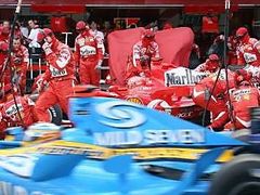 Fernando Alonso s Renaultem (vpředu) projíždí kolem boxů Ferrari svého rivala v boji o titul Michaela Schumachera.