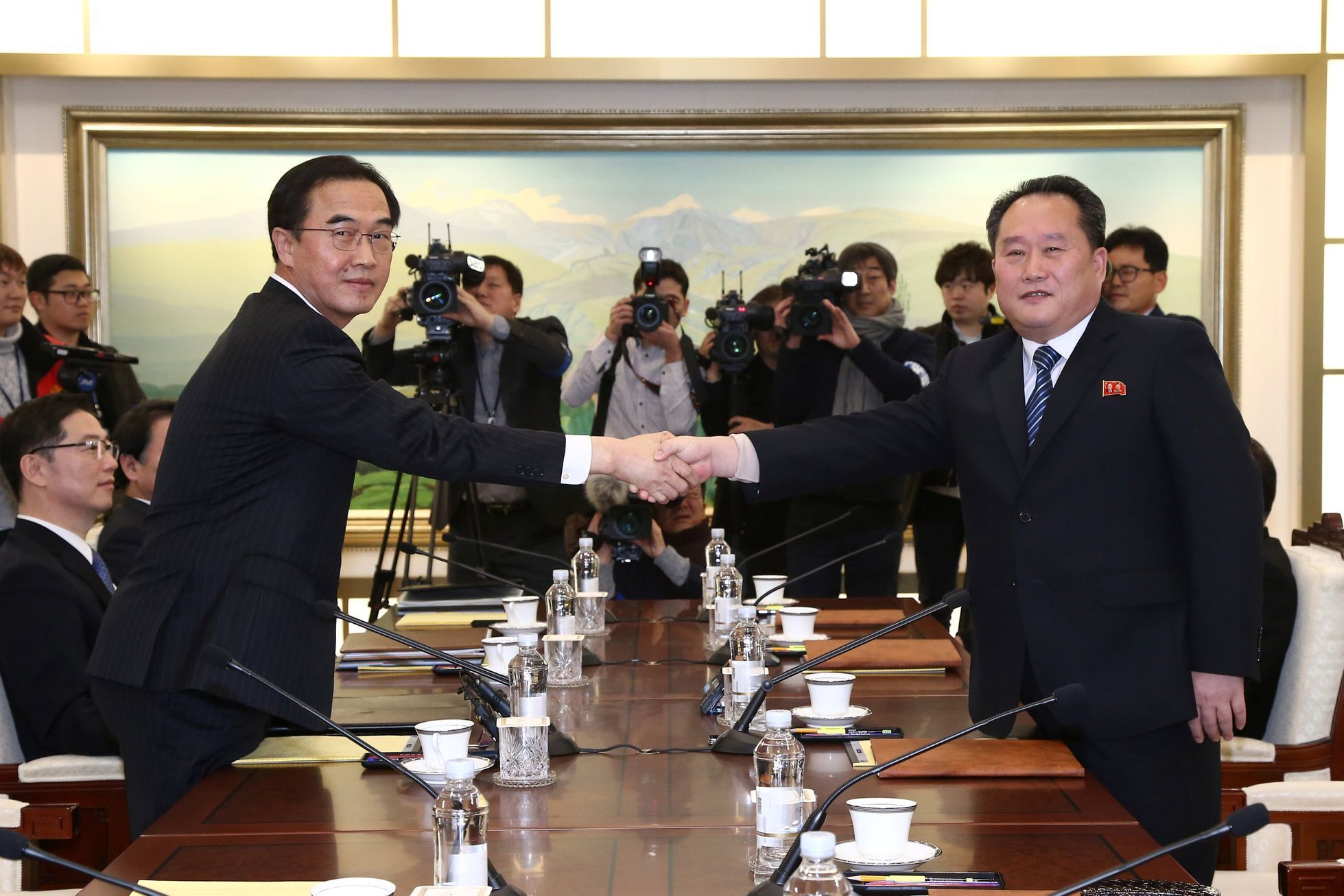 Šéf severokorejské delegace si třese pravicí s jihokorejským ministrem pro sjednocení Čo Mjong-kjonem.