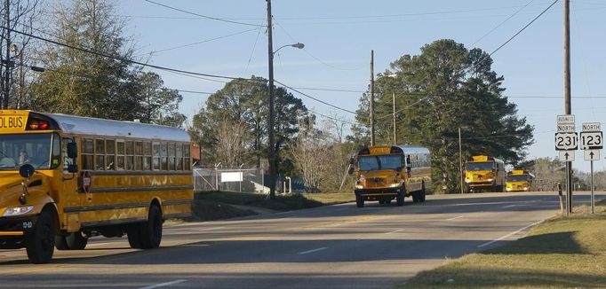 A line of school buses in the procession to the gravesite after the funeral for bus driver Charles Albert Poland Jr. at Ozark Civic Center, near Midland City, Alabama, February 3, 2013. Mourners in the small town of Midland City, Alabama, gathered on Sunday to bury a school bus driver slain during the abduction of a child taken captive and held for a sixth day by a gunman in an underground bunker. REUTERS/Phil Sears (UNITED STATES - Tags: CRIME OBITUARY) Published: Úno. 4, 2013, 12:47 dop.