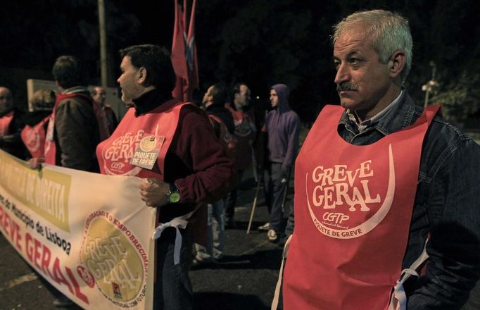 Rubbish collectors, wearing vests that read "General strike", stand on a picket line at the entrance of a garage in Lisbon November 13, 2012. Portuguese workers began to walk-out on the eve of the November 14 general strike on Tuesday (November 13) in protest against policies that are cutting social benefits, reducing wages and increasing taxes as part of an austerity programme designed to slash Portugal's public deficit after the country asked for a 78 billion euro bailout last year. REUTERS/Jose Manuel Ribeiro (PORTUGAL - Tags: POLITICS BUSINESS EMPLOYMENT CIVIL UNREST) Published: Lis. 14, 2012, 12:04 dop.