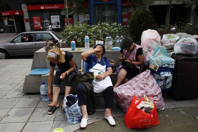 Rosa Maria Sastre Castilla, 46, (L-R), her mother Carmen Castilla, 77, and her sister Carmen Aurora, 49, sit with their belongings on the street that has been their home for the past two weeks in Madrid June 8, 2012. All of them, as well as their 44-year-old sister Antonia (not pictured), were evicted from their rental apartment on April 24 after Rosa, the sole breadwinner, lost her job and couldn't pay for the monthly rent. Social services provided them temporary lodging for 15 days, and after that they found themselves on the street. They all sleep cramped in a tiny space outside a store nearby. "If I could find a job again and we could get social rent, I'm sure we could make it work again, " says Rosa. As of now, the family lives on their mother's widow's pension as well as the little money they get from Antonia's disability check and whatever Carmen Aurora can scrape by working as a concierge at a nearby building. "The people in this neighbourhood are very nice. Many bring us food and try to make us more comfortable here," says Rosa. Picture taken June 8, 2012. REUTERS/Susana Vera (SPAIN - Tags: SOCIETY POVERTY BUSINESS) Published: Čer. 9, 2012, 1:44 odp.