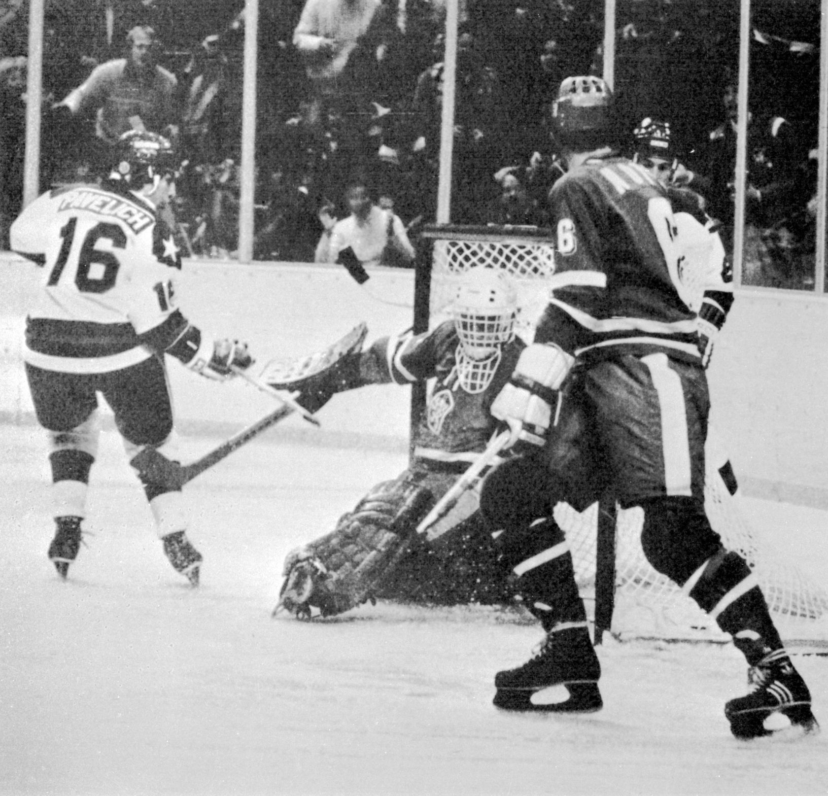 Americký hokejista Mark Pavelich střílí druhý gól do sítě Jiřího Králíka, vpravo Milan Nový v zápase ZOH 1980 ČSSR - USA 3:7.