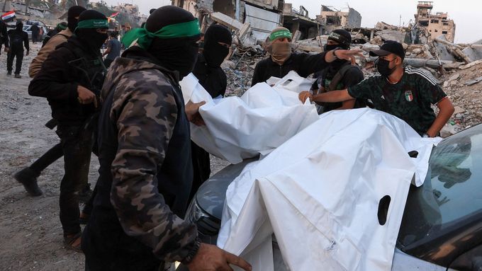 Příslušníci Hamásu nesou těla.