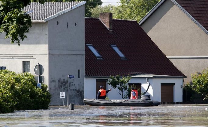 Firefighters use a boat to search for residents after the river Elbe flooded the village of Kabelitz, north of Magdeburg June 10, 2013. Tens of thousands of people have been forced to leave their homes and there have been at least a dozen deaths as a result of floods that have hit Germany, Austria, Slovakia, Poland and the Czech Republic over the past week. REUTERS/Fabrizio Bensch (GERMANY - Tags: DISASTER ENVIRONMENT)