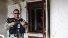 A police officer guards onboard a North Korean flagged ship "Chong Chon Gang" docked at the Manzanillo Container Terminal in Colon City July 16, 2013. Panama detained the North Korean-flagged ship from Cuba as it headed to the Panama Canal and said it was hiding weapons in brown sugar containers, sparking a standoff in which the ship's captain attempted to commit suicide. Panama's President Ricardo Martinelli said the undeclared weapons were detected inside the containers when Panamanian authorities stopped the ship, suspecting it was carrying drugs. REUTERS/Carlos Jasso (PANAMA - Tags: CRIME LAW DRUGS SOCIETY POLITICS) Published: Čec. 16, 2013, 9:13 odp.