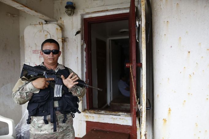 A police officer guards onboard a North Korean flagged ship "Chong Chon Gang" docked at the Manzanillo Container Terminal in Colon City July 16, 2013. Panama detained the North Korean-flagged ship from Cuba as it headed to the Panama Canal and said it was hiding weapons in brown sugar containers, sparking a standoff in which the ship's captain attempted to commit suicide. Panama's President Ricardo Martinelli said the undeclared weapons were detected inside the containers when Panamanian authorities stopped the ship, suspecting it was carrying drugs. REUTERS/Carlos Jasso (PANAMA - Tags: CRIME LAW DRUGS SOCIETY POLITICS) Published: Čec. 16, 2013, 9:13 odp.