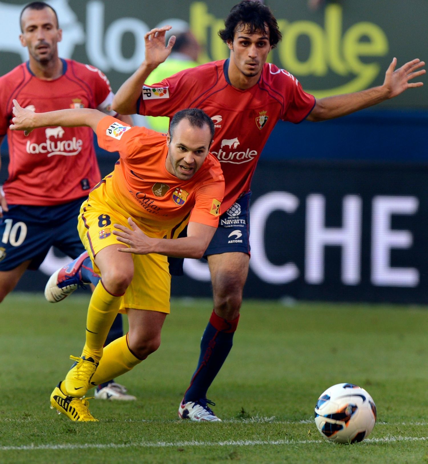 Fotbalista Barcelony Andrés Iniesta uniká před Alejandrem Arribasem v utkání La Ligy 2012/13 s Osasunou.