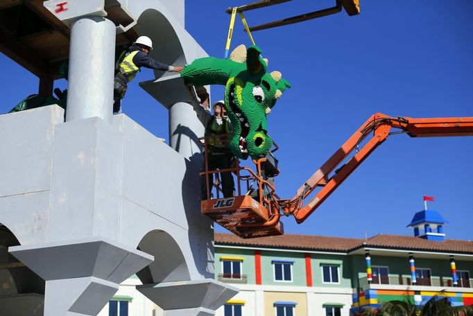 Workers hoist a dragon's head made of Lego bricks into position as construction continues on North America's first ever Lego Hotel being built at Legoland in Carlsbad, California January 17, 2013. The three-storey, 250-room hotel will open April 5. REUTERS/Mike Blake (UNITED STATES - Tags: SOCIETY BUSINESS EMPLOYMENT TRAVEL CONSTRUCTION) Published: Led. 17, 2013, 11:36 odp.