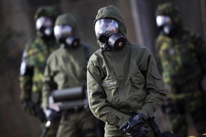 Brazilian army soldiers wearing chemical suits participate in an anti-terror simulation exercise as part of the preparation for the upcoming 2013 FIFA Confederations Cup in Brasilia. May 22, 2013. About 100 soldiers took part in the exercise which include preventive strikes against chemical, biological and radiological weapons conducted around Mane Garrincha National Stadium, according to an official statement. REUTERS/Ueslei Marcelino (BRAZIL - Tags: SPORT SOCCER MILITARY) Published: Kvě. 22, 2013, 9:43 odp.