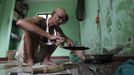 Mahesh Chaturvedi, 63, who dresses up like Mahatma Gandhi, cooks lunch at his residence in the outskirts of New Delhi October 23, 2012. Chaturvedi says that the soul of Gandhi resides in him and he has been sent to continue the work of Father of the Nation. After his self proclaimed transformation in 2002 as Gandhi, Chaturvedi has been travelling extensively and plays up to his startling resemblance to Gandhi at protests and demonstrations. Picture taken October 23, 2012. REUTERS/Mansi Thapliyal (INDIA - Tags: SOCIETY) Published: Lis. 26, 2012, 3:52 dop.