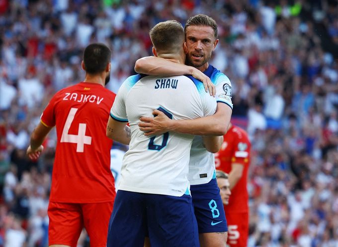 Angličtí fotbalisté Luke Shaw a Jordan Henderson slaví gól v utkání kvalifikace Euro 2024 proti Severní Makedonii