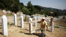 A worker carries a wooden frame while preparing graves for a ceremony at a memorial centre for Srebrenica Massacre victims in Potocari July 7, 2012. Tens of thousands of family members, foreign dignitaries and guests are expected to attend a ceremony in Srebrenica on July 11 marking the 17th anniversary of the massacre in which Bosnian Serb forces commanded by Ratko Mladic killed up to 8,000 Muslim men and boys. Nearly 510 identified victims will be buried at a memorial cemetery during the ceremony, their bodies found in some 60 mass graves around the town. REUTERS/Dado Ruvic (BOSNIA - Tags: POLITICS CONFLICT ANNIVERSARY) Published: Čec. 7, 2012, 3:30 odp.