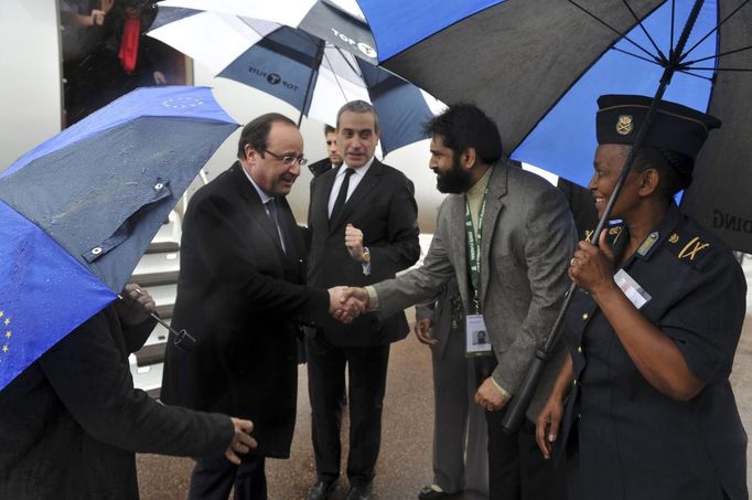 French President Francois Hollande (L) is greeted by officials on his arrival at Air Force Base Waterkloof, Pretoria December 10, 2013, in this handout picture provided by the South African Government Communication and Information System (GCIS).