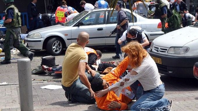 Dobrovolníci dávají první pomoc zraněným po sebevražedném atentátu v Tel Avivu.