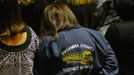 A woman wearing a bus driver's jacket from Escambia County, Florida attends the funeral for bus driver Charles Albert Poland Jr. at Ozark Civic Center, near Midland City, Alabama, February 3, 2013. Mourners in the small town of Midland City, Alabama, gathered on Sunday to bury a school bus driver slain during the abduction of a child taken captive and held for a sixth day by a gunman in an underground bunker. REUTERS/Phil Sears (UNITED STATES - Tags: CRIME OBITUARY) Published: Úno. 4, 2013, 1:18 dop.