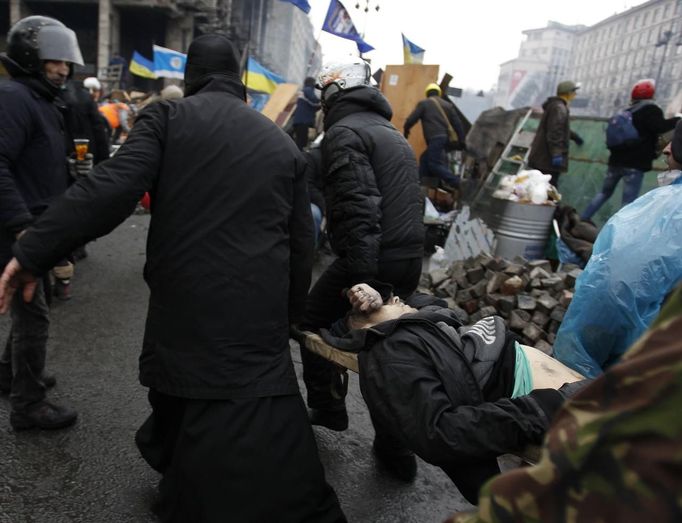 Anti-government protesters carry an injured man on a stretcher in Independence Square in Kiev February 20, 2014. Ukrainian anti-government protesters on Thursday seized b