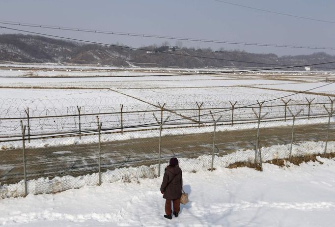 A woman, who was originally from North Korea, looks north after a memorial service for her North Korean ancestors in the direction of North Korea, near the demilitarized zone separating the two Koreas, in Paju, 55 km (34 miles) north of Seoul February 10, 2013, on the occasion of Seolnal, the Korean Lunar New Year's day. Millions of South Koreans travelled to their hometowns during the three-day holiday which started last Saturday. Seolnal is one of the traditional holidays when most Koreans visit their hometowns to be united with their families and hold memorial services for their deceased ancestors. REUTERS/Lee Jae-Won (SOUTH KOREA - Tags: MILITARY POLITICS SOCIETY) Published: Úno. 10, 2013, 6:20 dop.