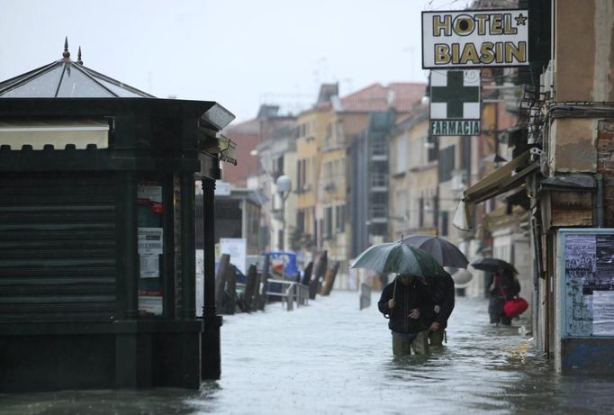 People walk in a flooded street during a period of seasonal high water in Venice November 11, 2012. The water level in the canal city rose to 149 cm (59 inches) above normal, according to local monitoring institute Center Weather Warnings and Tides. REUTERS/Manuel Silvestri (ITALY - Tags: ENVIRONMENT SOCIETY) Published: Lis. 11, 2012, 2:10 odp.