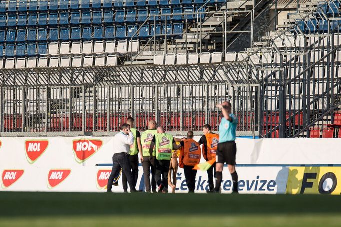 Pořadatelé odvádějí polonahého fanouška, který vběhl na hrací plochu v posledních minutách zápasu.