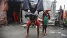 Drumpal Choudhary, 11, a street performer, does a hand stand in front of his hut in the slum on the bank of Manahara River before leaving to perform on the streets of Kathmandu August 15, 2012. Drumpal and his siblings, Shivani and Gchan, who came to Kathmandu from India 5 years ago, earn their living by performing tricks on the streets of Kathmandu. According to Drumpal, Shivani's older brother, they earn around $10 a day by performing tricks, which is not enough to feed their 10-member family living together in a small hut without a proper toilet or any basic needs. REUTERS/Navesh Chitrakar (NEPAL - Tags: SOCIETY IMMIGRATION POVERTY TPX IMAGES OF THE DAY) Published: Srp. 15, 2012, 4:03 odp.