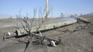 A telephone pole, damaged from the so-called Dump Fire, smolders on the ground after being replaced outside of an explosives plant near Saratoga Springs, Utah, June 23, 2012. A raging Utah brush fire ignited by target shooting in dry grass has forced some 8,000 people from their homes in two small communities since June 22 as high winds fanned flames toward a nearby explosives factory, authorities said. REUTERS/Jeff McGrath (UNITED STATES - Tags: ENVIRONMENT DISASTER) Published: Čer. 24, 2012, 2:43 dop.