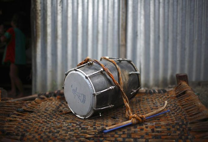 A drum belonging to Gchan Choudhary, 17, a street performer, lies outside his hut in the slum on the bank of Manahara River before he leaves to perform on the streets of Kathmandu August 15, 2012. Gchan and his siblings Shivani and Drumpal, who came to Kathmandu from India 5 years ago, earn their living by performing tricks on the streets of Kathmandu. According to Drumpal, Shivani's older brother, they earn around $10 a day by performing tricks, which is not enough to feed their 10-member family living together in a small hut without a proper toilet or any basic needs. REUTERS/Navesh Chitrakar (NEPAL - Tags: SOCIETY POVERTY IMMIGRATION) Published: Srp. 15, 2012, 4:14 odp.