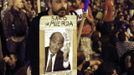 A protester leans on his sign showing Spain's Economy Minister Luis de Guindos and reading "Sack of Shit" as anti-austerity demonstrators continued into the night near the Spanish parliament in Madrid September 25, 2012. Anti-austerity demonstrators protested in Madrid ahead of the government's tough 2013 budget that will cut into social services as the country teeters on the brink of a bailout. REUTERS/Paul Hanna (SPAIN - Tags: POLITICS CIVIL UNREST BUSINESS) TEMPLATE OUT Published: Zář. 25, 2012, 10:58 odp.