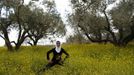 Palestinian runner Maslaha stretches as she practises at a field belonging to her family near Nablus