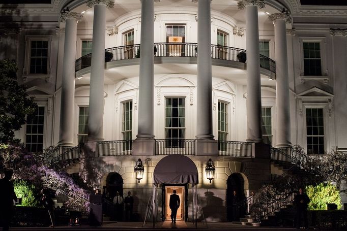 March 30, 2012 "We had just arrived aboard the Marine One helicopter on the South Lawn and the President was walking into the White House. I had seen this scene several times but had never been able to quite capture it the way I wanted. Here, finally, arriving at night, I was able to frame him walking into the light of the Diplomatic Reception Room, with the added bonus of his shadow being cast from the television lights off to the left."