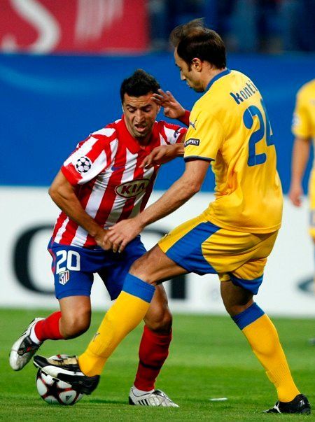 Simao (Atletico) a Kontis (APOEL Atletico) v souboji v utkání Ligy mistrů.