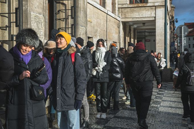 Městská knihovna v Praze a turisté čekající na fotku se sloupem z knih, tzv. Idiomem.