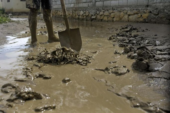 A Haitian man shovels mud from his yard which was flooded due to Tropical Storm Isaac in an area outside of Port-au-Prince August 26, 2012. Tropical Storm Isaac left six dead in Haiti, still recovering from a 2010 earthquake, and at least three missing in the Dominican Republic after battering their shared island of Hispaniola on Saturday. REUTERS/Swoan Parker (HAITI - Tags: DISASTER ENVIRONMENT SOCIETY) Published: Srp. 26, 2012, 5:43 odp.