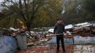 David Valdes Armendia, 7, lifts weights he found amidst debris as a bulldozer (L) demolishes the former school, where his grandparents lived at, in the Spanish gypsy settlement of Puerta de Hierro, in the outskirts of Madrid November 20, 2012. Fifty-four families have been living in Puerta de Hierro, on the banks of the Manzanares river for over 50 years. Since the summer of 2010, the community has been subject to evictions on the grounds that the dwellings are illegal. Families, whose homes have been demolished, move in with relatives whose houses still remain while the debris keeps piling up around them as more demolitions take place. REUTERS/Susana Vera (SPAIN - Tags: CIVIL UNREST BUSINESS CONSTRUCTION) Published: Lis. 20, 2012, 4:54 odp.