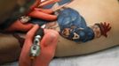 Artist Sean Karn applies a tattoo of Captain America on the leg of Ron Raucci during the Hampton Roads Tattoo Festival in Virginia March 2, 2012. The tattoo, completed from start to finish in just one five-and-a-half hour session, won the prestigious tattoo of the day prize at the festival. Picture taken March 2, 2012. REUTERS/Jason Reed (UNITED STATES - Tags: SOCIETY) ATTENTION EDITORS PICTURE 06 OF 31 FOR PACKAGE 'ADDICTED TO THE NEEDLE' TO FIND ALL PICTURES SEARCH 'ADDICTED NEEDLE' Published: Čer. 29, 2012, 12:58 odp.