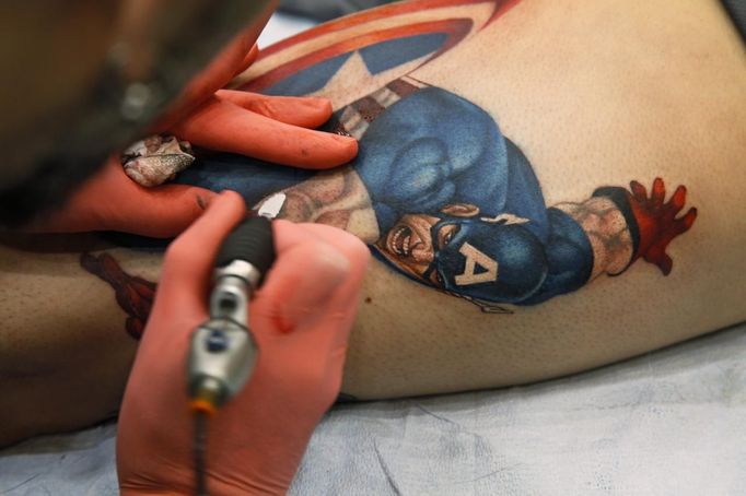 Artist Sean Karn applies a tattoo of Captain America on the leg of Ron Raucci during the Hampton Roads Tattoo Festival in Virginia March 2, 2012. The tattoo, completed from start to finish in just one five-and-a-half hour session, won the prestigious tattoo of the day prize at the festival. Picture taken March 2, 2012. REUTERS/Jason Reed (UNITED STATES - Tags: SOCIETY) ATTENTION EDITORS PICTURE 06 OF 31 FOR PACKAGE 'ADDICTED TO THE NEEDLE' TO FIND ALL PICTURES SEARCH 'ADDICTED NEEDLE' Published: Čer. 29, 2012, 12:58 odp.