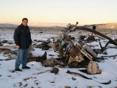 Veterán "Guerra de Las Malvinas" Ernesto Alonso stojí vedle zbytků sestřelené argentinské helikoptéry Chinook nedaleko kopce Two sisters.
