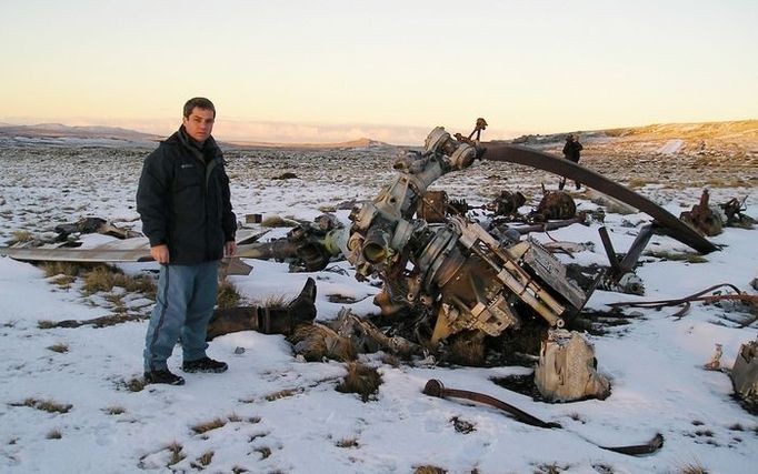 Veterán "Guerra de Las Malvinas" Ernesto Alonso stojí vedle zbytků sestřelené argentinské helikoptéry Chinook nedaleko kopce Two sisters.