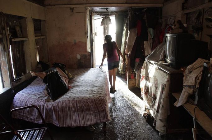 Ruth walks inside a train carriage she calls home in Cadereyta on the outskirts of Monterrey August 8, 2012. Ruth, her eight other family members and their pets have been living in the abandoned carriage next to a train track for the last 15 years. Ruth's grandparents moved from Tamaulipas to Cadereyta after one of their sons was killed on the street by a stray bullet. The family moved into the carriage, which was empty after having been occupied by a vagabond, after living for the first five years in a rented room after arriving in Cadereyta. Picture taken August 8, 2012. REUTERS/Daniel Becerril (MEXICO - Tags: SOCIETY) Published: Srp. 11, 2012, 2:14 dop.