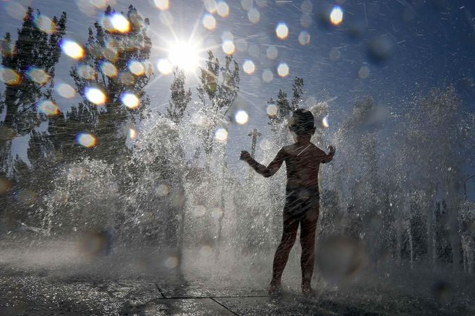 A child cools off in a fountain on a hot summer day in downtown Donetsk June 22, 2012. REUTERS/Alessandro Bianchi (UKRAINE - Tags: SOCIETY ENVIRONMENT TPX IMAGES OF THE DAY) Published: Čer. 22, 2012, 4:28 odp.