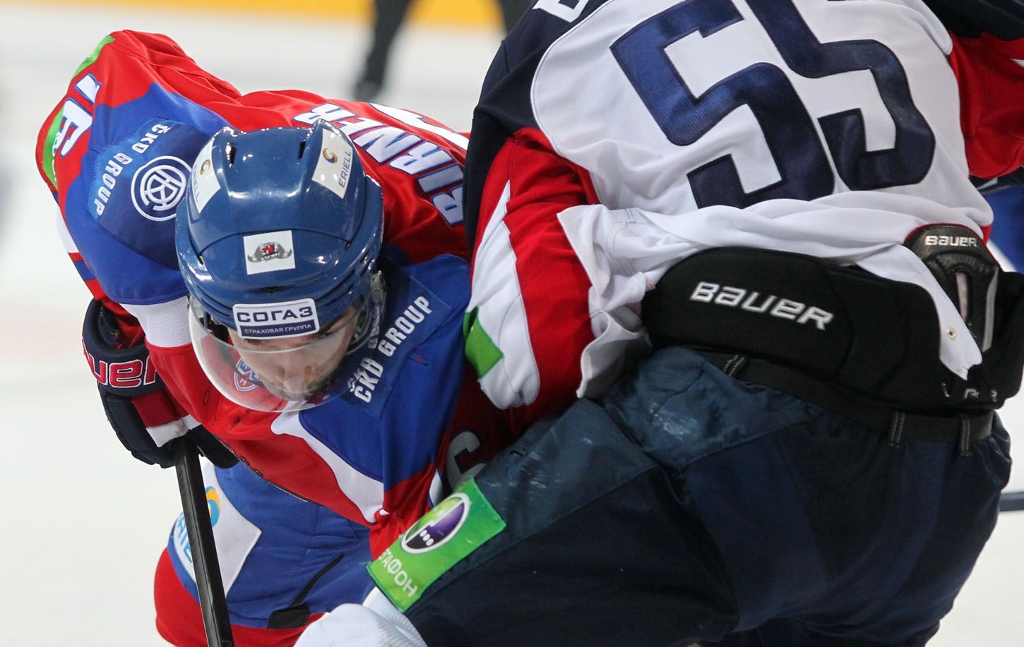 Hokejista Lva Praha Michal Birner v souboji s Mario Bližňákem v utkání KHL 2012/13 proti Slovanu Bratislava.