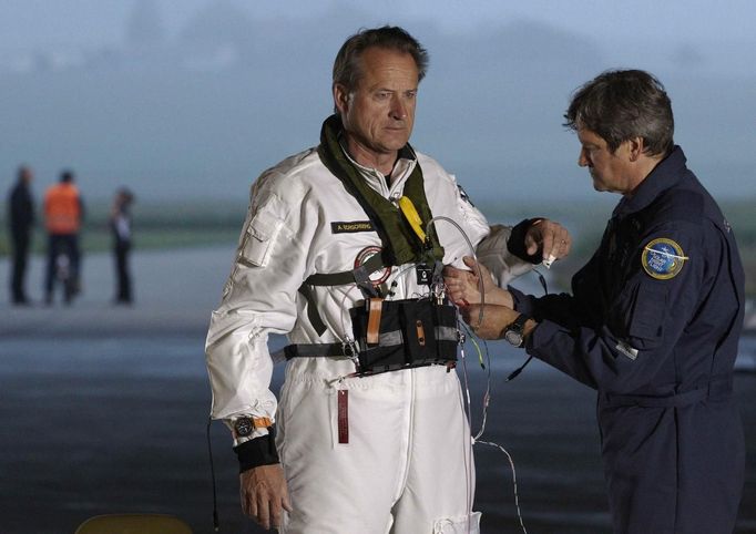 Solar Impulse project CEO and pilot Andre Borschberg (L) puts on his suit before take off at Payerne airport May 24, 2012. The Solar Impulse HB-SIA prototype aircraft, which has 12,000 solar cells built into its 64.3 metres (193 feet) wings, attempted its first intercontinental flight from Payerne to Rabat in Morocco with a few days for a technical stop and a change of pilot in Madrid. This flight will act as a final rehearsal for the 2014 round-the-world flight. REUTERS/Denis Balibouse (SWITZERLAND - Tags: TRANSPORT SCIENCE TECHNOLOGY SOCIETY BUSINESS) Published: Kvě. 24, 2012, 8:09 dop.