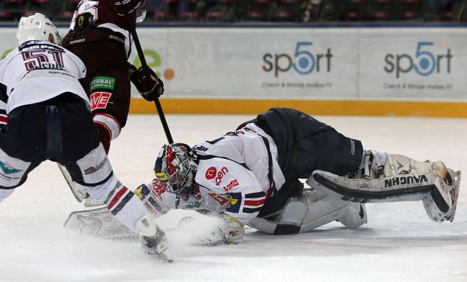 Hokejisté Chomutova Lukáš Pulpán a Milan Řehoř (brankář) brání Dominika Pacovského v utkání 16. kola Tipsport extraligy 2012/13 proti Spartě Praha.