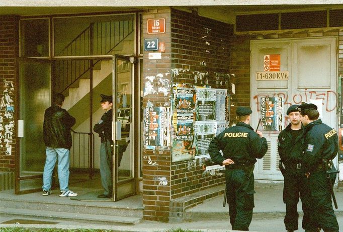 Policisté hlídkují před domem v Táboritské ulici číslo 22 v Praze na Žižkově, na jehož chodbě byl zastřelen třicetiletý kriminalista, 1998.