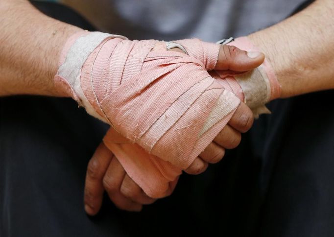 The hands of unemployed Belgian Mohamed Sammar are seen during a "Fit for a job" boxing class in Brussels July 1, 2013. Sammar, 27, has been looking for a job in the construction sector for 2 years. "Fit for a job" is the initiative of former Belgian boxing champion Bea Diallo, whose goal was to restore the confidence of unemployed people and help them find a job through their participation in sports. Picture taken July 1, 2013. REUTERS/Francois Lenoir (BELGIUM - Tags: SPORT BOXING SOCIETY TPX IMAGES OF THE DAY BUSINESS EMPLOYMENT) Published: Čec. 5, 2013, 4:14 odp.