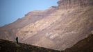 A woman walks on a hill before sunrise after the Perseid meteor shower, in Ramon Carter near the town of Mitzpe Ramon, southern Israel