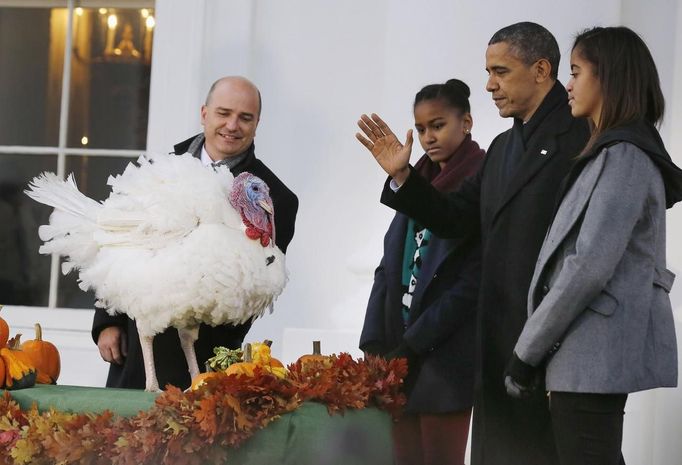 Americký prezident Barack Obama, doprovázený svými dcerami, omilostňuje krocana jménem Popcorn.